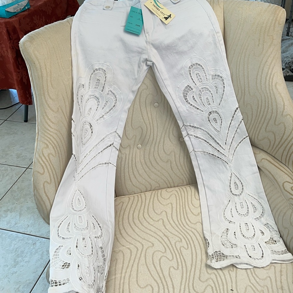 Unworn white denim jeans with cut out designs on front and back of jeans